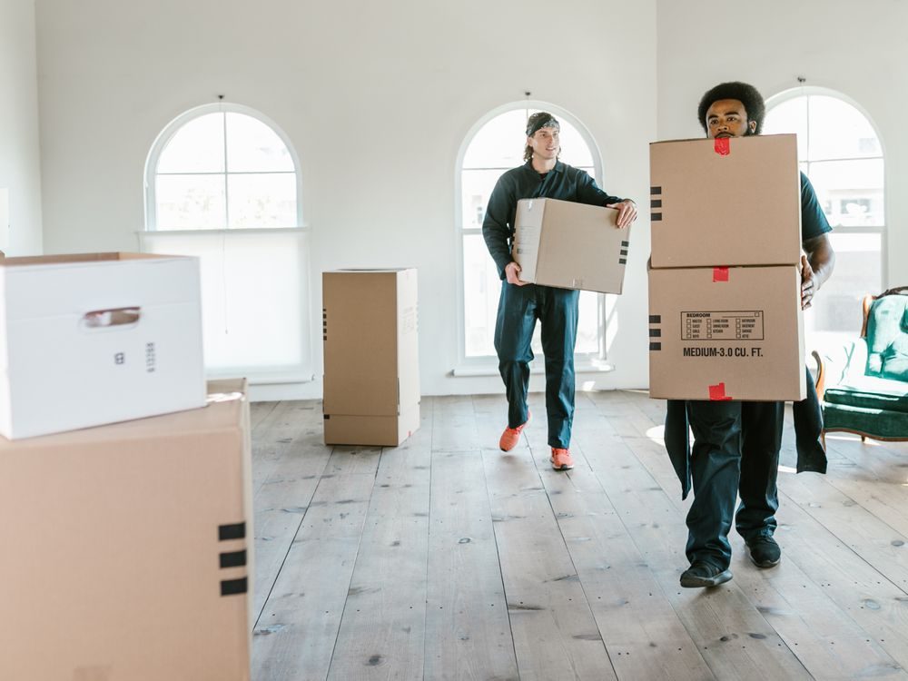Umzugsteam trägt Kartons in eine Wohnung